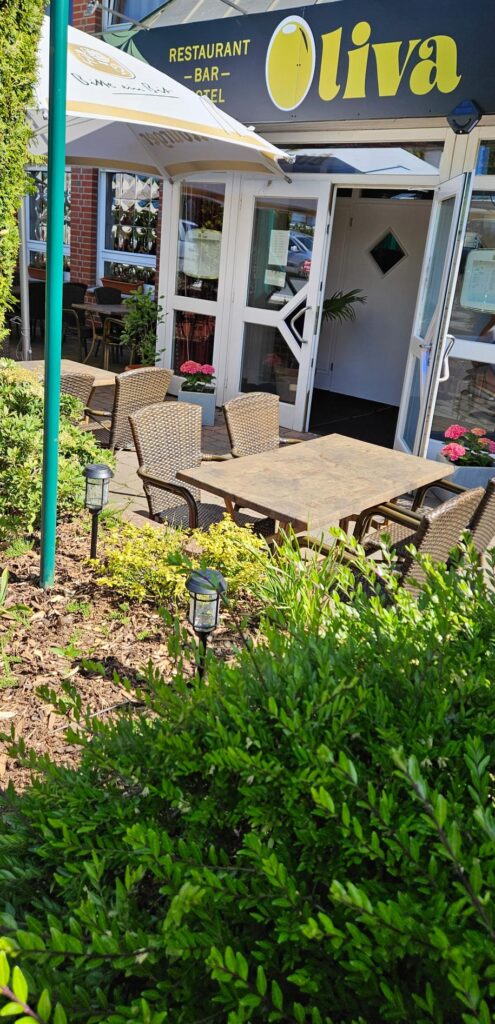 Ein leerer Außenbereich eines Restaurants mit Rattanstühlen und sonnigem Wetter
